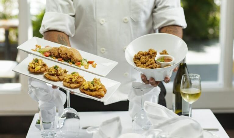 A chef serves elegant Caribbean starters—crispy bites, fried delights, and vibrant flavours—perfect for a gourmet experience - Tamarind Hills Resort and Villas - Antigua