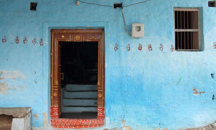 Blue house in Anegundi with a decorative door.