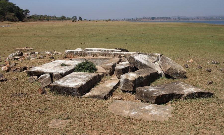 Ancient temple ruins on a dry grassy plain.