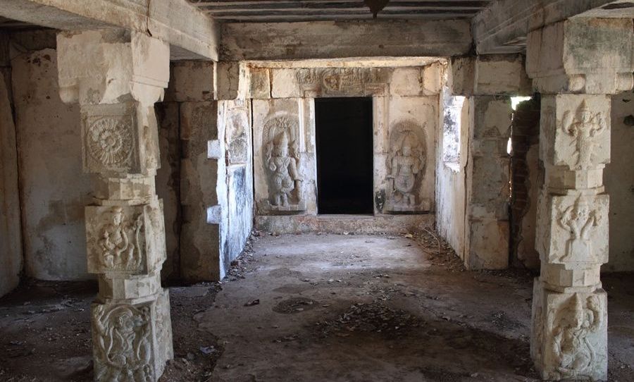 Ancient stone temple interior with carved pillars.