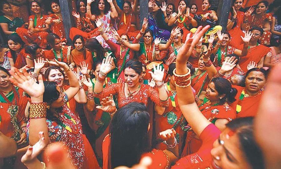 A group of women dancing wearing red saree