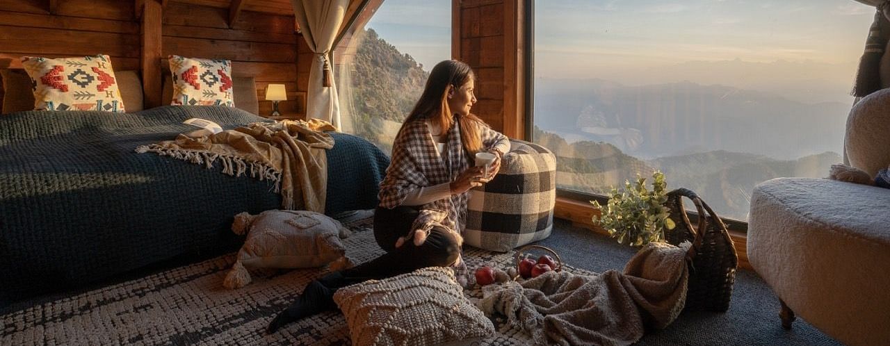 An image of woman enjoying the view with a cup of coffee