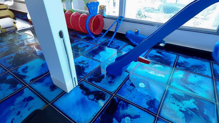 The Kids' Play Area with blue tiles featuring indoor activities for toddlers at Regenta Inn DLS.