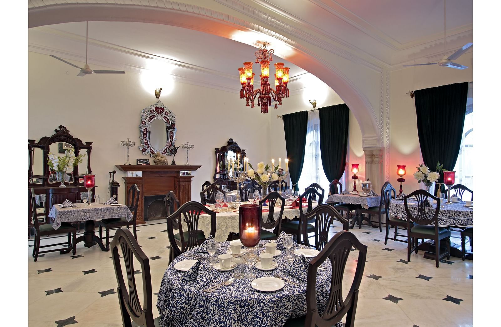 A lavish indoor dining area with classic interiors, chandeliers, and ornate furniture - Khas Bagh, Jaipur.