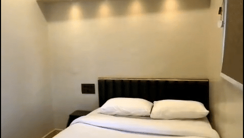 Minimalist deluxe room at Hotel Regal Heaven Pune featuring a neatly made bed, soft lighting, and modern interiors.