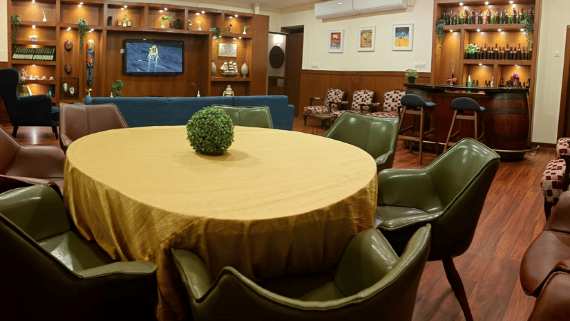A hotel lounge or restaurant area with a large round table and a couch.