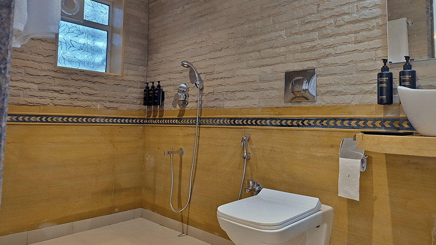 Bathroom with a toilet, shower area, washbasin, and tiled walls