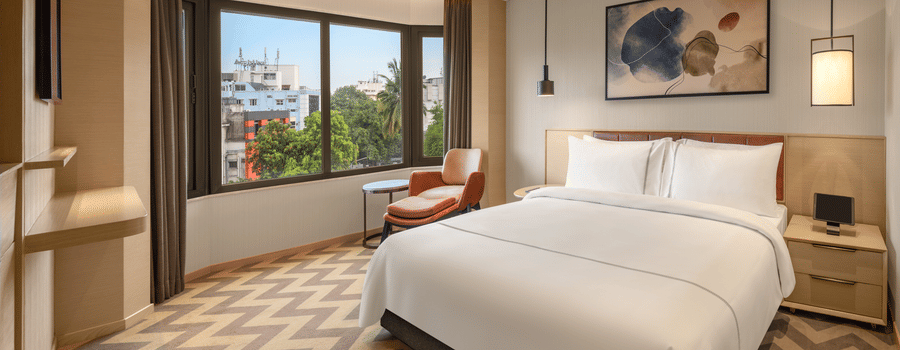 Suite room featuring a cosy bed and elegant bedside lamps at The Residency Chennai