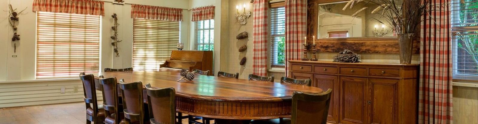 A rustic yet elegant private dining room at the Tallman Hotel with a large oval table and chandelier.