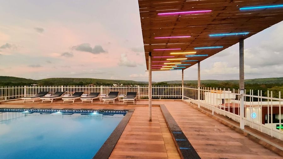 Sidewalk of the swimming pool with wooden floor and ceiling  at Vagator Downtown, Goa