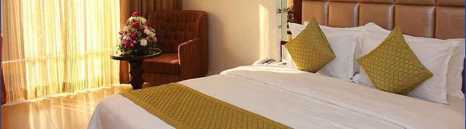 Image of a room with a bed and window on the side at Calux Grand Inn, Calangute.