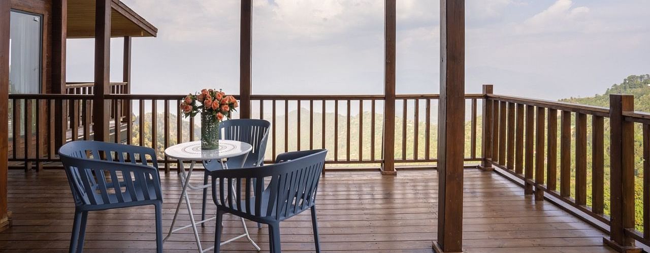 An image of a patio with a view along with seating and wooden flooring