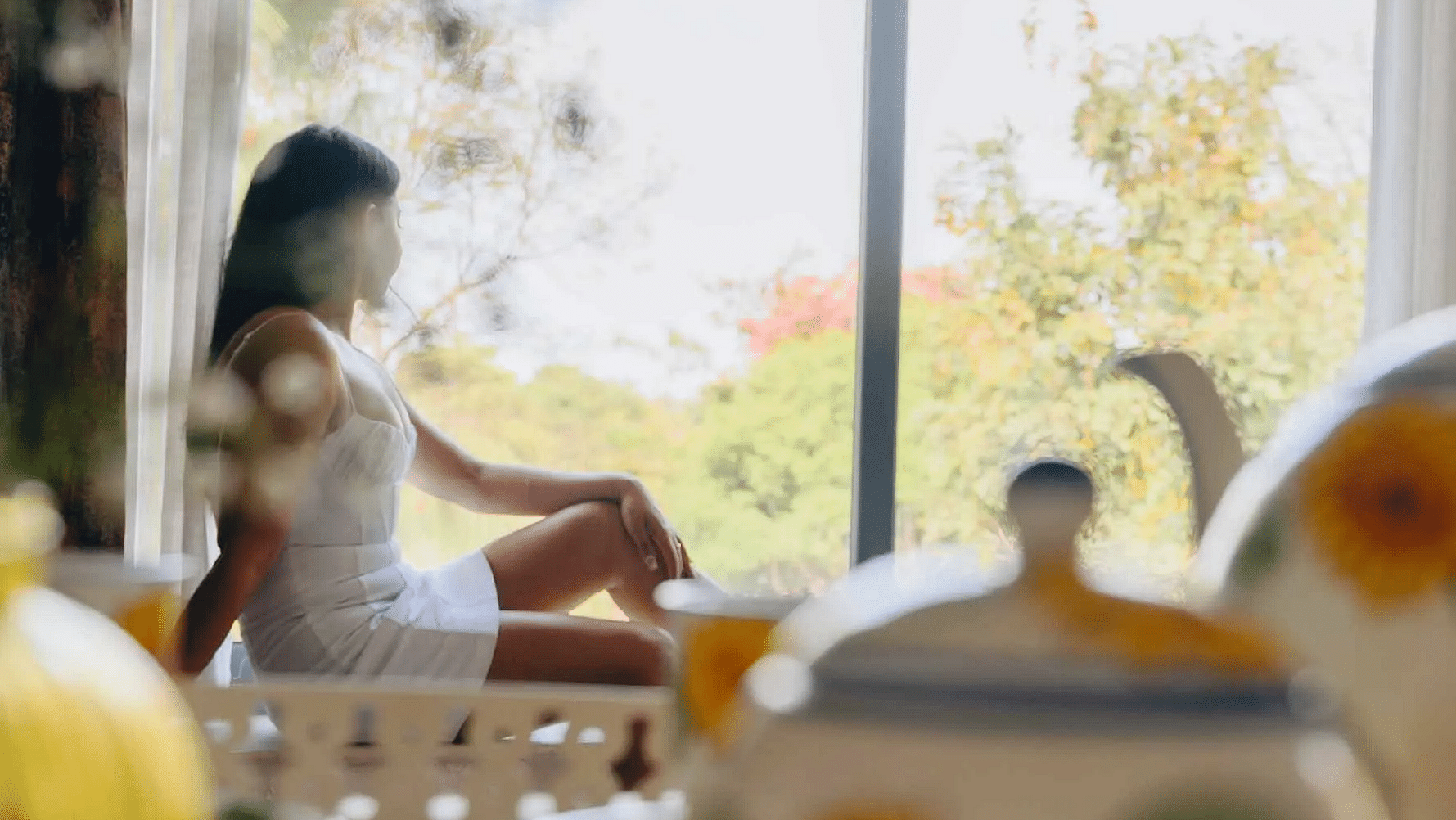 Women sitting on a window sill with teapots at Karma Chalets.