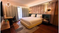 Spacious Bedroom with Modern Furniture and Artwork in Royal Suite at Pride Plaza Ahmedabad.