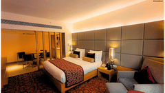 Premium hotel room with elegant decor, plush seating, and ambient lighting at Pride Plaza Ahmedabad