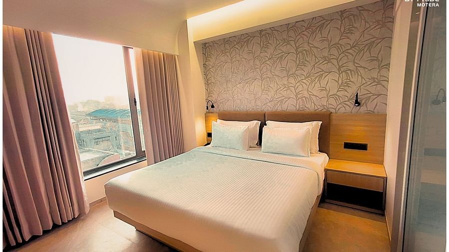 corner view image of a room featuring a double bed with curtains open showcasing huge windows - biznotel by pride, motera