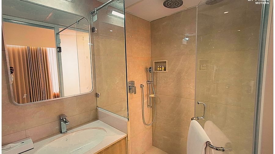 a bathroom featuring a walk in shower separated by a glass door - Biznotel by Pride, Motera