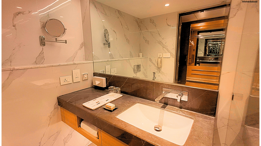 Deluxe King Room at Pride Plaza Ahmedabad with a stylish marble bathroom vanity, large mirror, premium fittings and contemporary design offering both functionality and refined comfort.