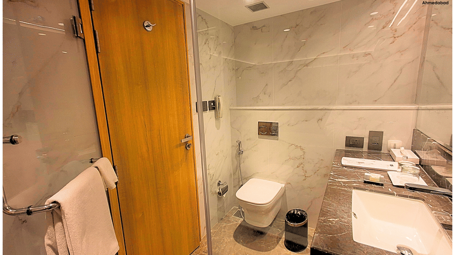 Superior King Room at Pride Plaza Ahmedabad offering a well appointed marble bathroom with glass shower enclosure, modern sanitary fittings and neatly arranged bath amenities.