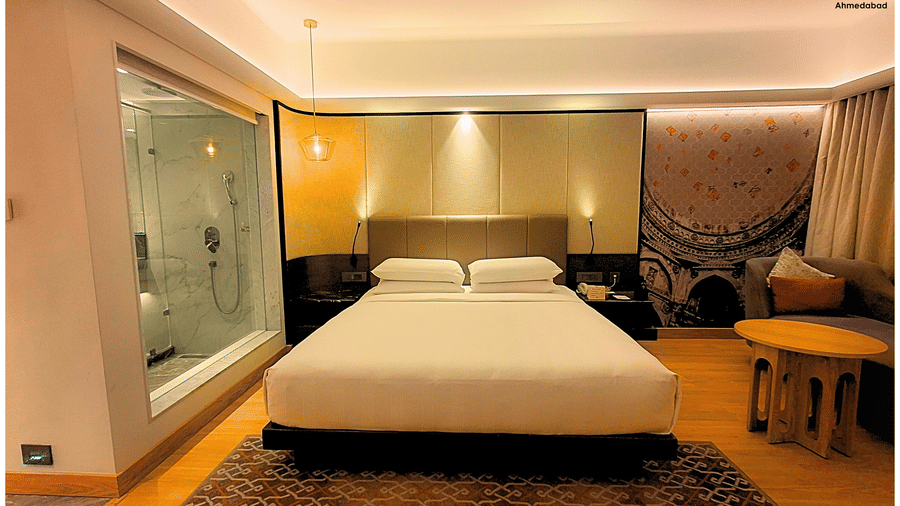Superior King Room at Pride Plaza Ahmedabad presenting a wide view of the bedroom with king size bed, work desk, seating area, wooden flooring and contemporary interior styling.