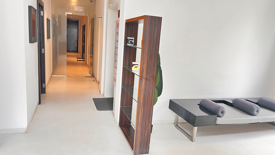 A bright hallway with a wooden divider, cushioned seating, and neatly arranged towels creating a welcoming, calming environment at Springs Hotel & Spa, Bangalore