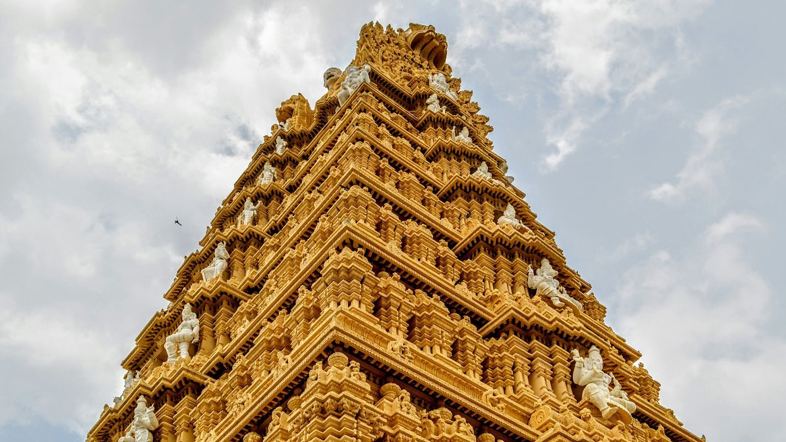 Golden temple gopuram with intricate carvings and ornate detailing.