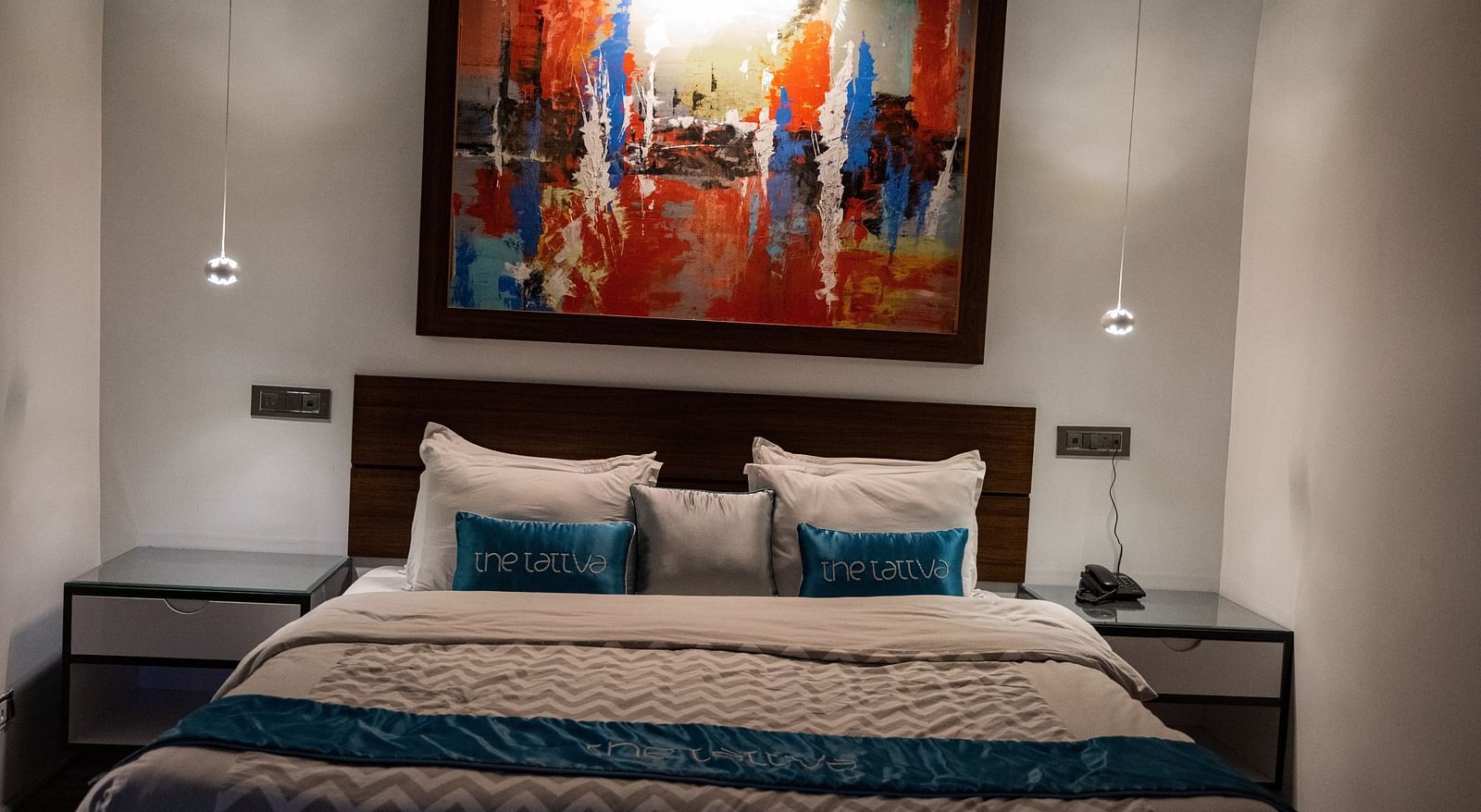 image of the bedroom featuring a double bed with a beautiful paining hanging above it - The Tattva Boutique Resort