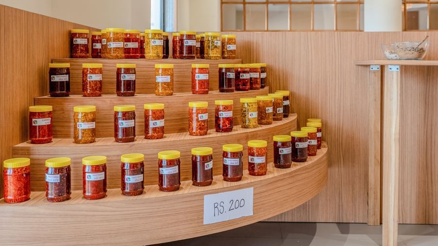 A close-up shot of a corner featuring several varieties of pickles kept on display along with a placard reading 200 Rupees at Daksh The Grand Goverdhan, Dwarka.