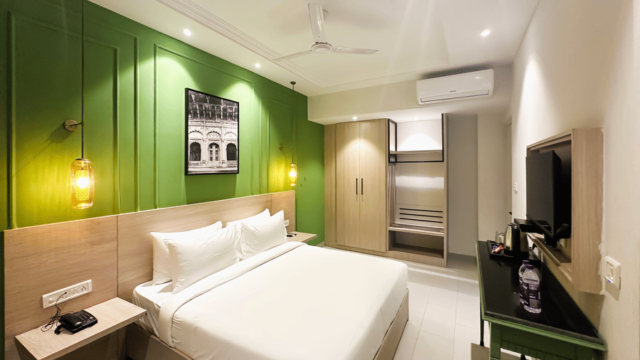 A hotel room with a large bed in front of a television - Wonder Hills