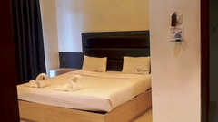 A double bed with side tabled and dove towels on the bed at the family room - Hotel Shompen