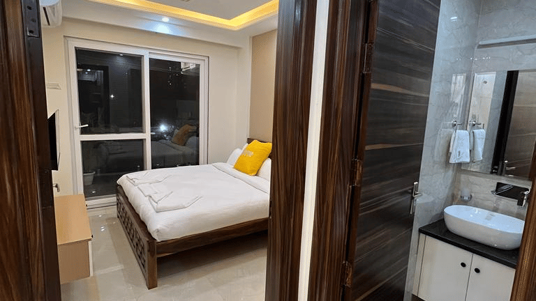 Bedroom of Lime Tree Hotels & Service Apartment Private Limited featuring a view through an open door into an adjoining bedroom.