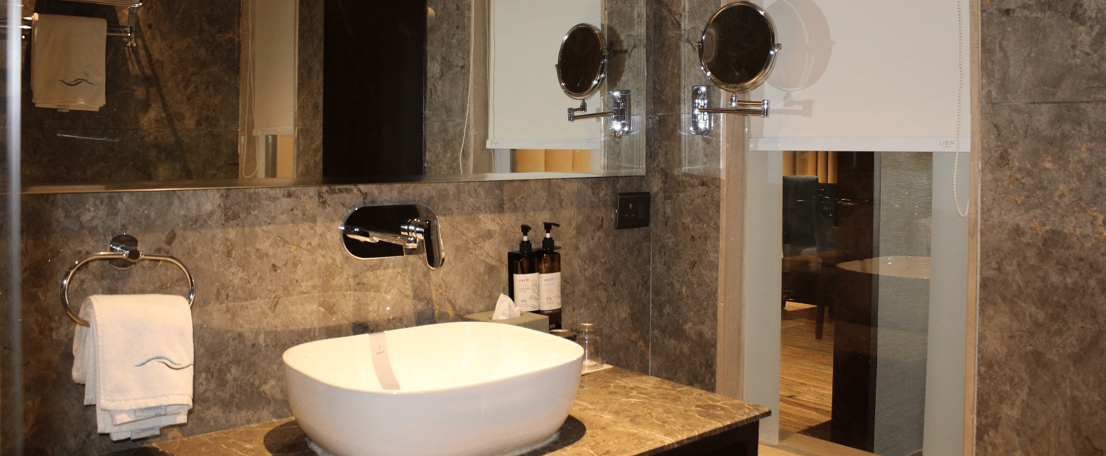 A bathroom with a wash basin and a mirror 
