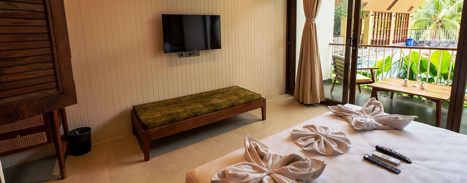Spacious bedroom with large windows, comfortable bedding, and a flat-screen TV, offering a relaxed atmosphere - Sea Hills Resort, Swaraj Dweep (Havelock)