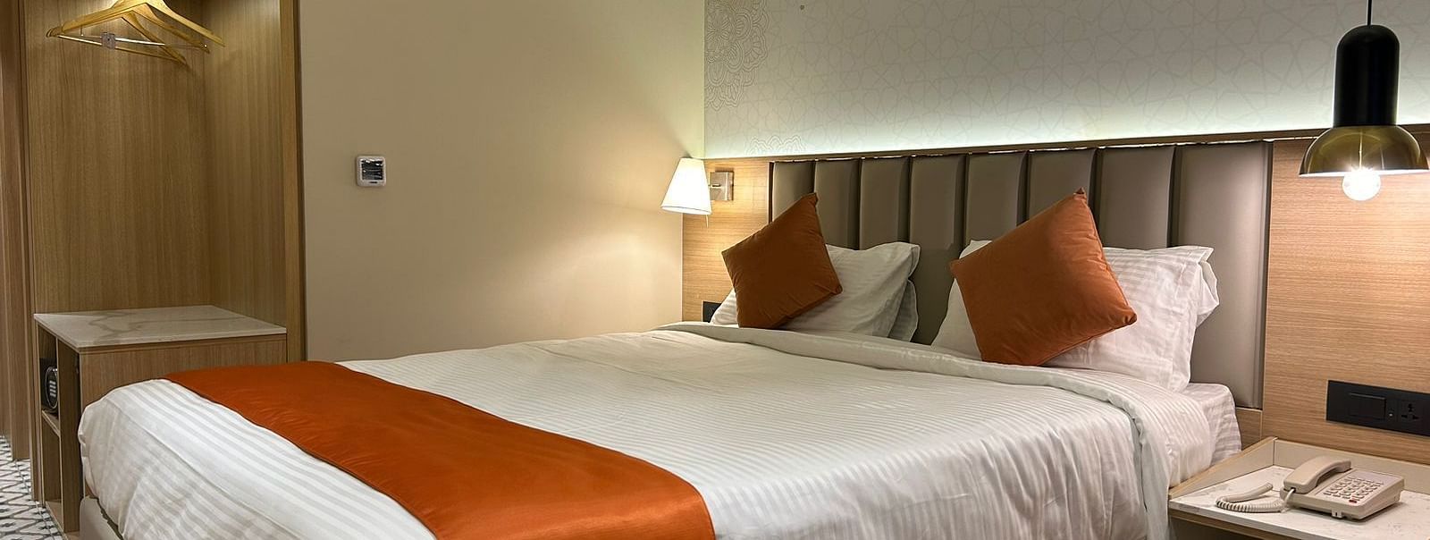A cosy room with warm lighting, a bed, bedside tables, and lamps - TGI Oberon, Koramangala
