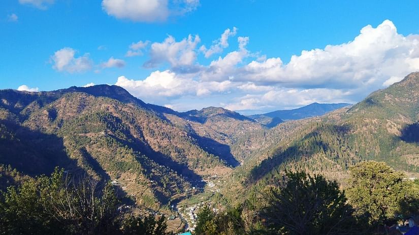 View of lush mountains with a blue sky with could scattered around