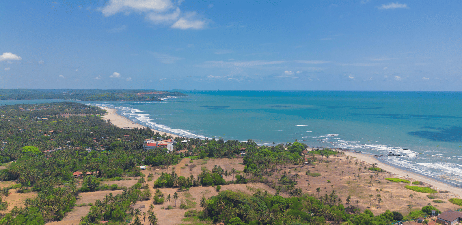 An aerial view of Morjim Beach with waves gently reaching the shore - Perfectstayz Koko Maya