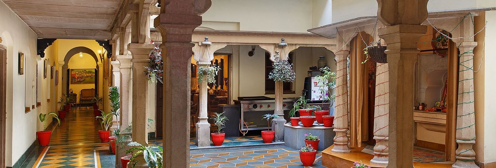 Hotel pathway lined with small potted plants at the corners.