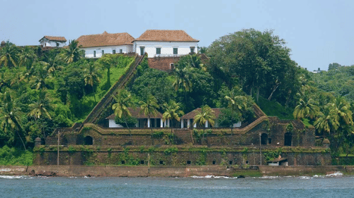 Lush greenery surrounding a fort on an island with buildings in the background