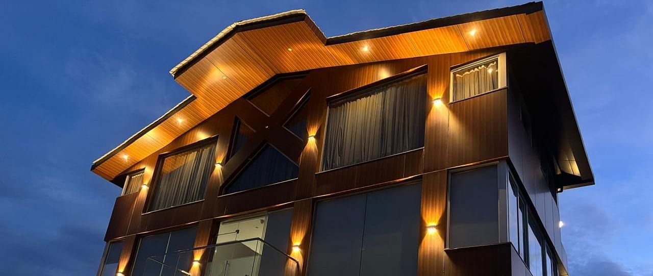 close up image of the facade of Eminence The Corbett with exterior lighting and beautiful evening sky in the background