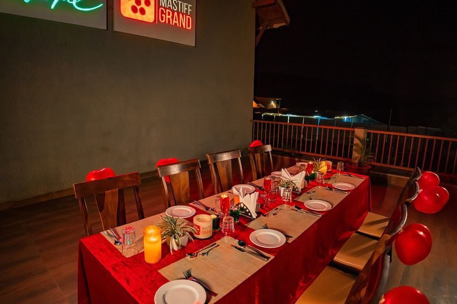 Dining setup with decorated tables and chairs arranged for a group gathering at the restaurant - Mastiff Grand La Villae Resort, Lonavala