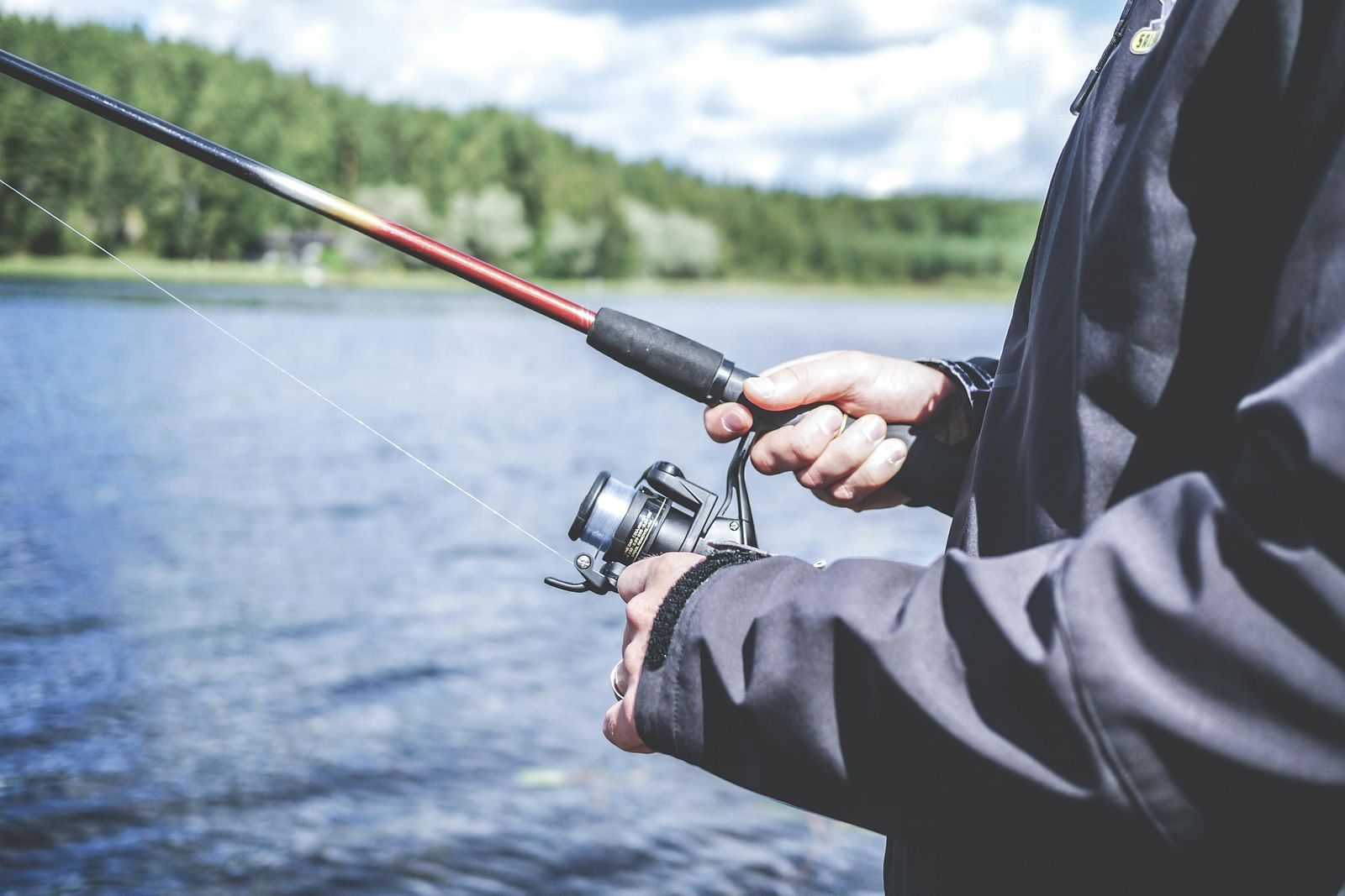 A person fishing with a rod and reel in a lake.