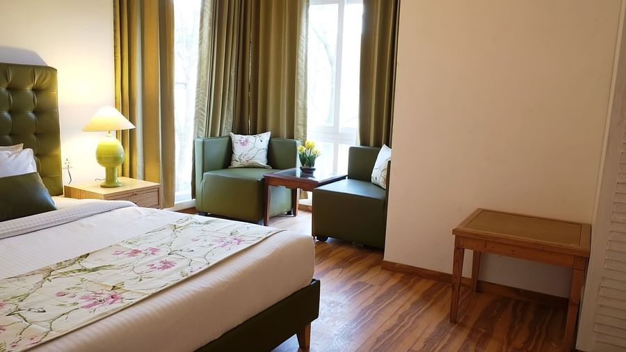 Cosy hotel room featuring a comfortable bed and soft curtains.