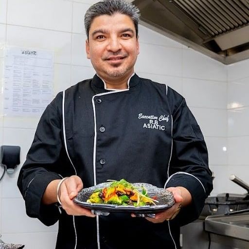 Rajendra Bishowkarma, the executive chef posing with one of his dishes