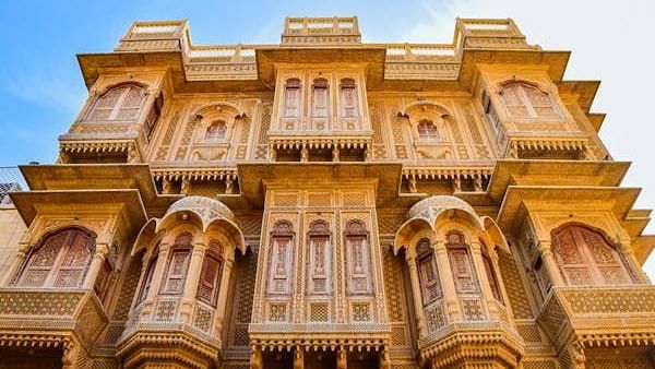 Elaborately carved sandstone building facade with ornate windows and balconies.