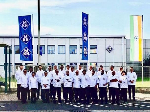 Staff posing for a group picture infront of the hotel.