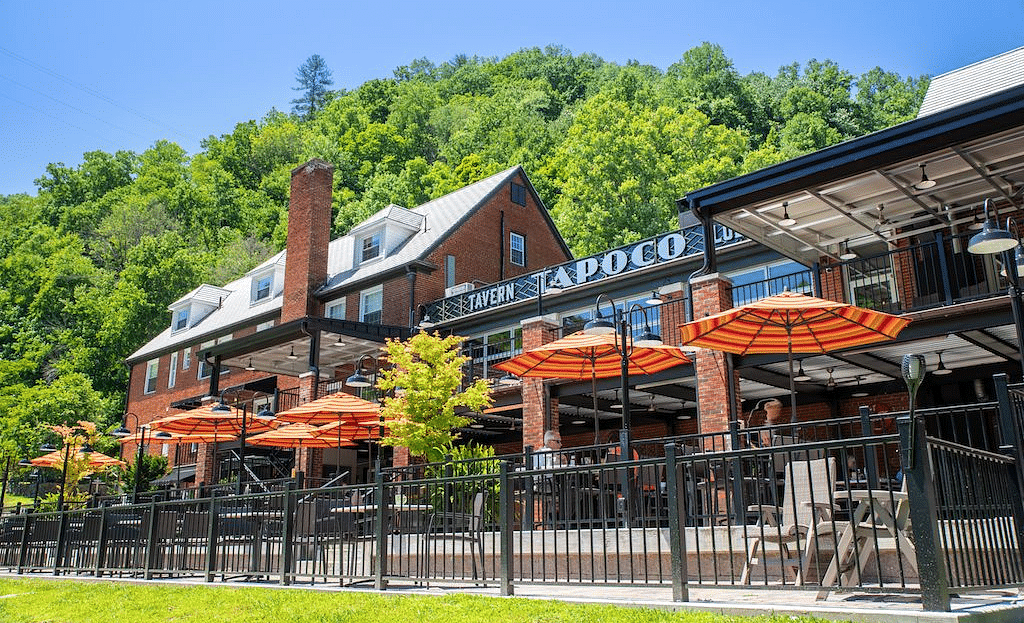 a bright facade image of the Historic Tapoco Lodge taken from a lower angle with a bright clear blue sky in the background - Historic Tapoco Lodge