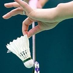 image of a person about the serve the shuttle cock with a badminton racket
