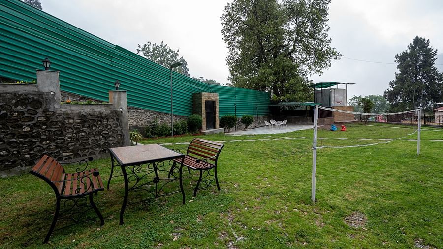 Two chairs and a table in the open area by the badminton court at The Pavilion, Nainital