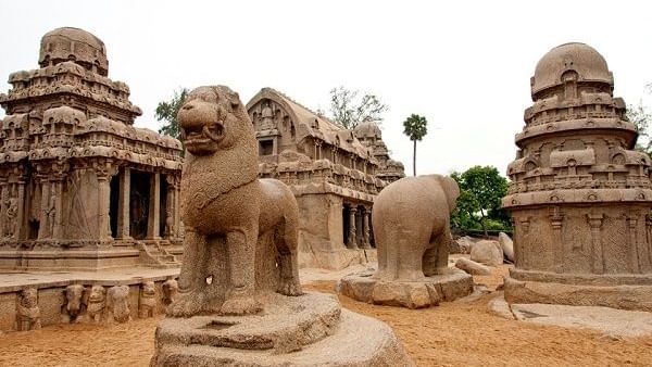 A rock-cut lion sculpture and temple structures with carvings and another sculpture, near Hotel Mamallaa Heritage, Mahabalipuram.
