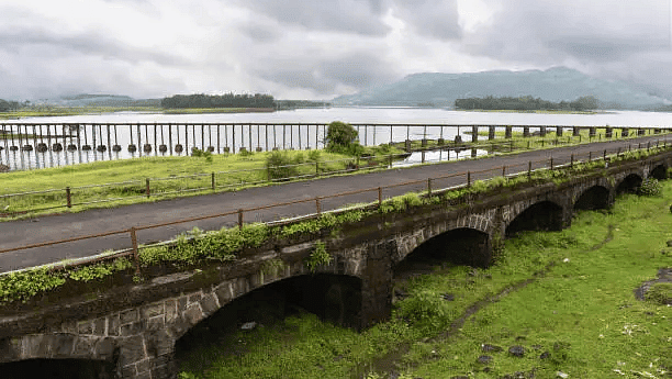 Scenic view of a historic stone bridge stretching across a green landscape.